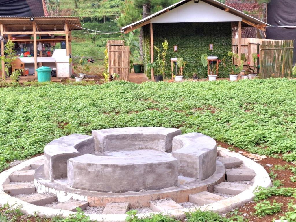 a stone bench sitting in the middle of a yard at Aubrey Villa Ciwidey in Pengalengan