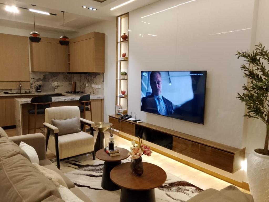 a living room with a large flat screen tv on a wall at Pazo by TLL in Ilorin