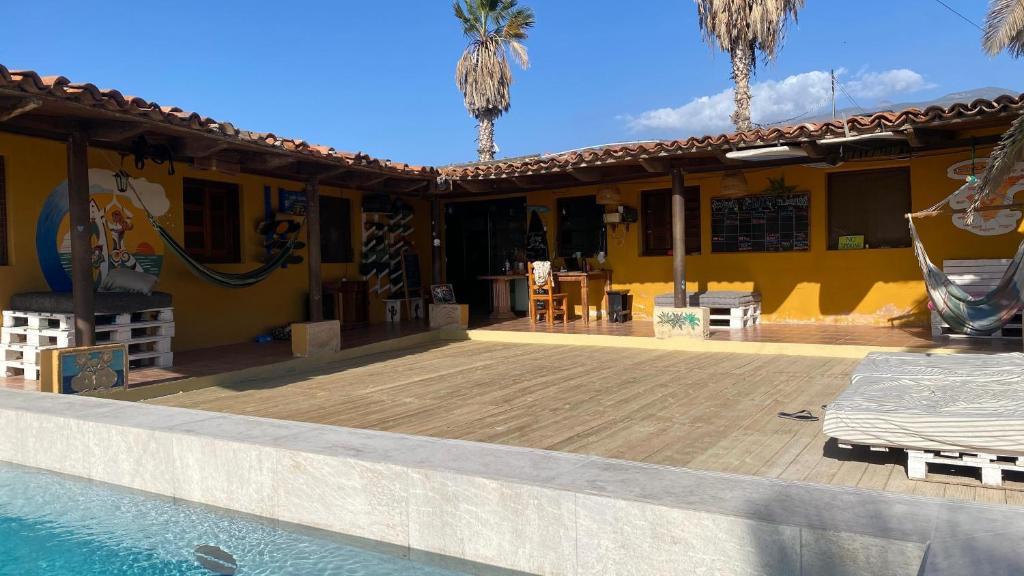 a house with a swimming pool next to a building at The Tree House Surf Camp in Adeje