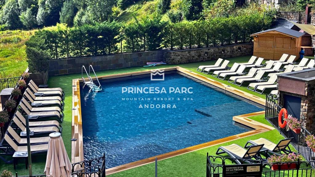 a swimming pool with chairs and a sign that reads pinesias park at Hotel Princesa Parc Excellence in Arinsal