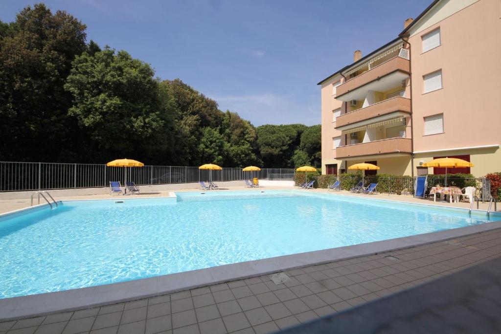 a large swimming pool in front of a building at Bright flat in Rosolina with shared pool in Rosolina Mare