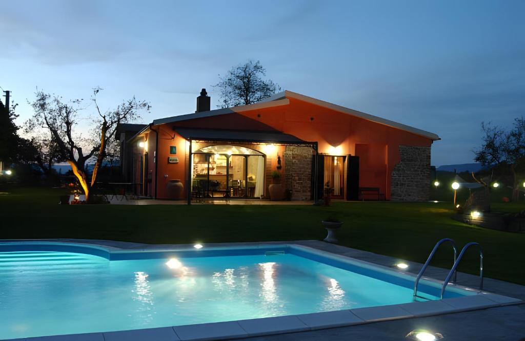 Agriturismo Il Maggio - Manciano في مانشانو: مسبح امام بيت بالليل