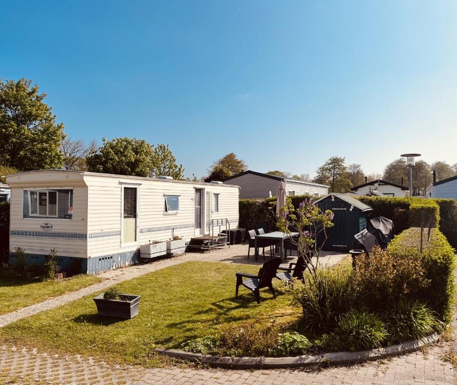 an rv parked in a yard with a patio at Camping de Zandput - ZP 340 in Vrouwenpolder
