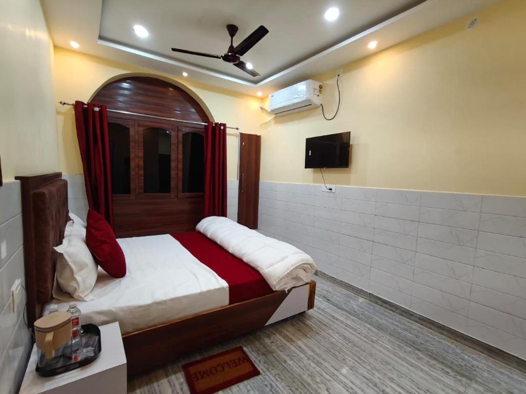 een slaapkamer met een bed en een televisie. bij Shree Gopal Inn in Varanasi