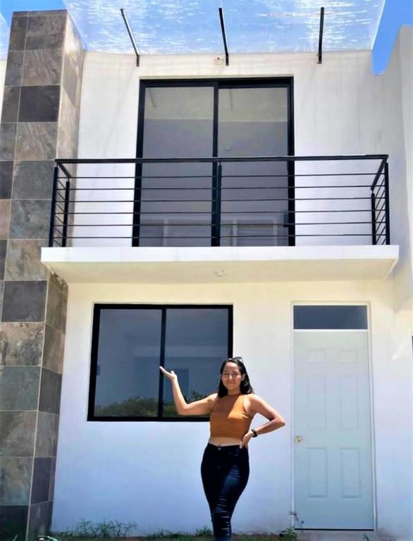 埃斯孔迪多港casa vacacional MELISSA的站在房子前面的女人