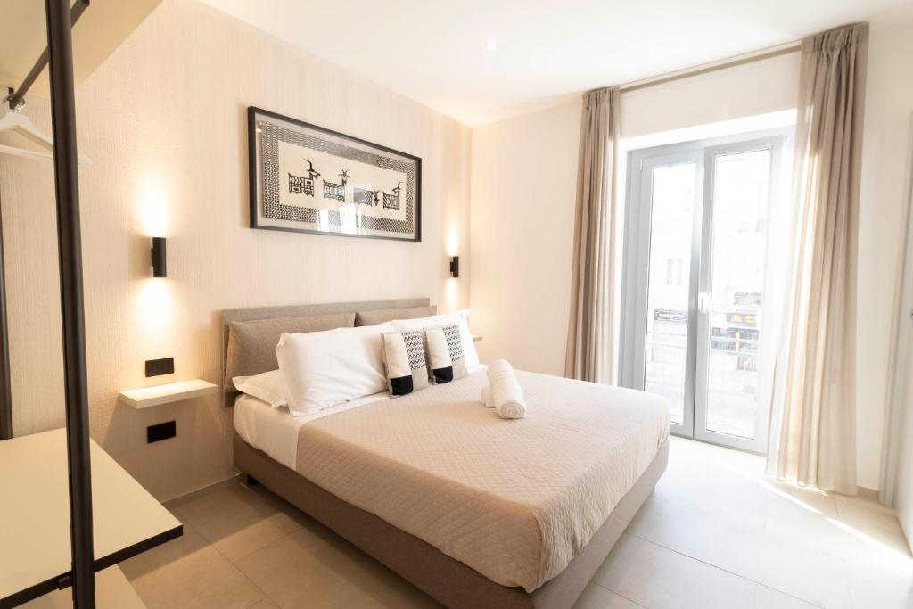 a bedroom with a bed and a large window at Sardinian Days - Suites & Rooms in Cagliari