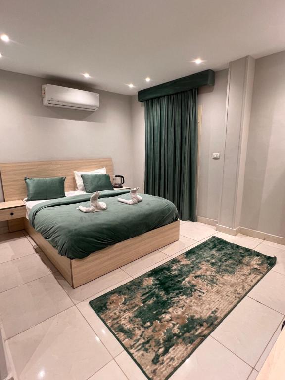 カイロにあるFanton Hotelのベッドルーム1室(ベッド1台、緑のシーツ、ラグ付)