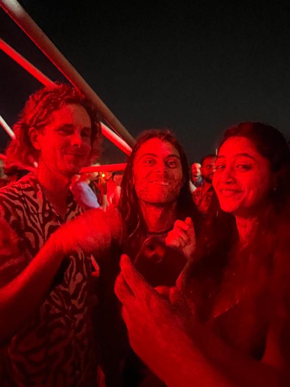 eine Gruppe von Menschen, die mit roten Lichtern bedeckt sind in der Unterkunft The Peace Hostel in Arambol