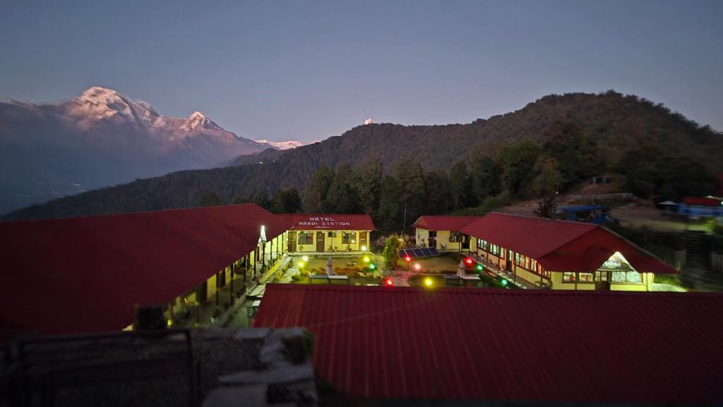 a large building with a mountain in the background at Hotel mardi station in Astam