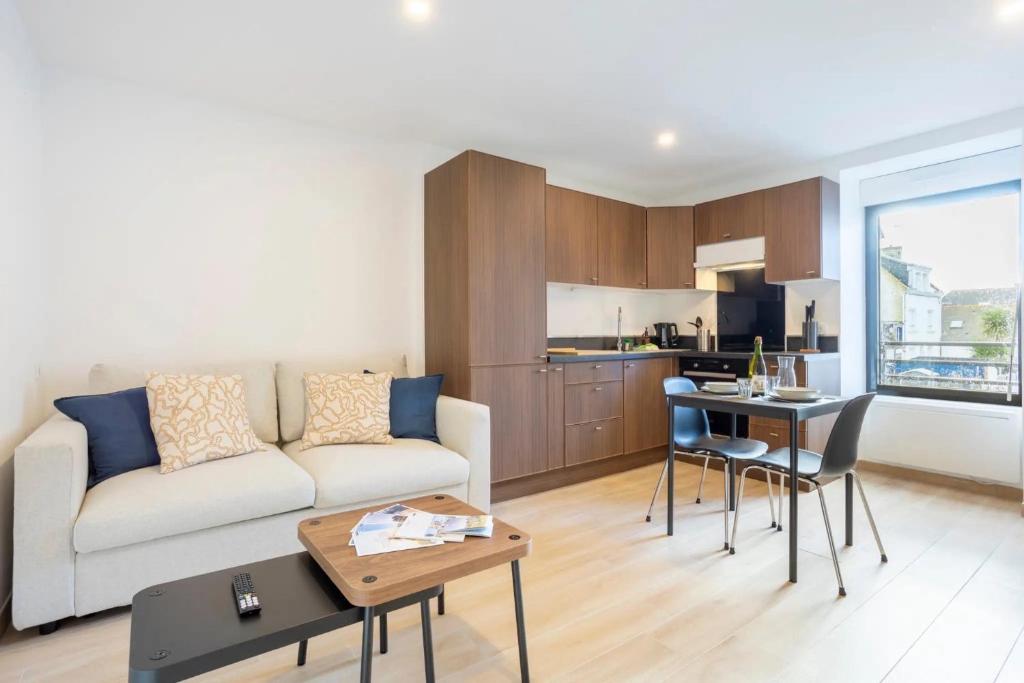 ル・ギルヴィネックにあるLes studios Bigoudensのソファとテーブルのあるリビングルーム