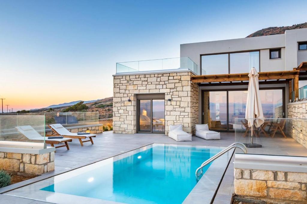 a villa with a swimming pool and a house at Anemelia Villas in Karpathos