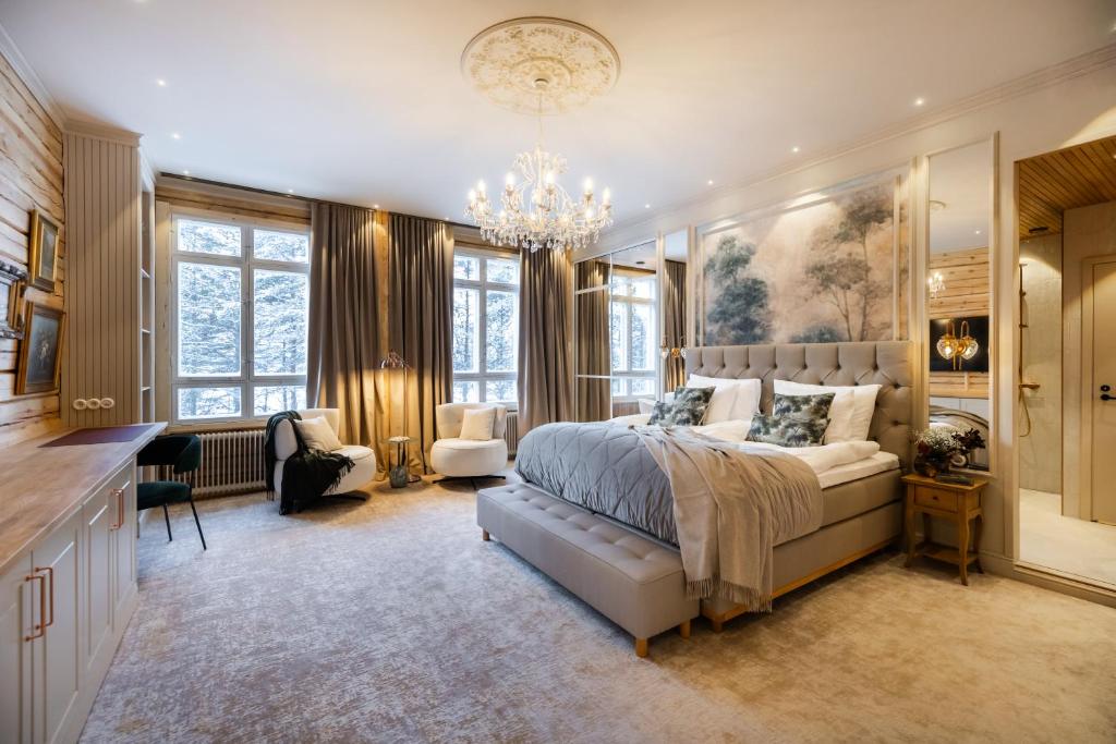a bedroom with a large bed and a chandelier at Skýra Retreat in Rovaniemi