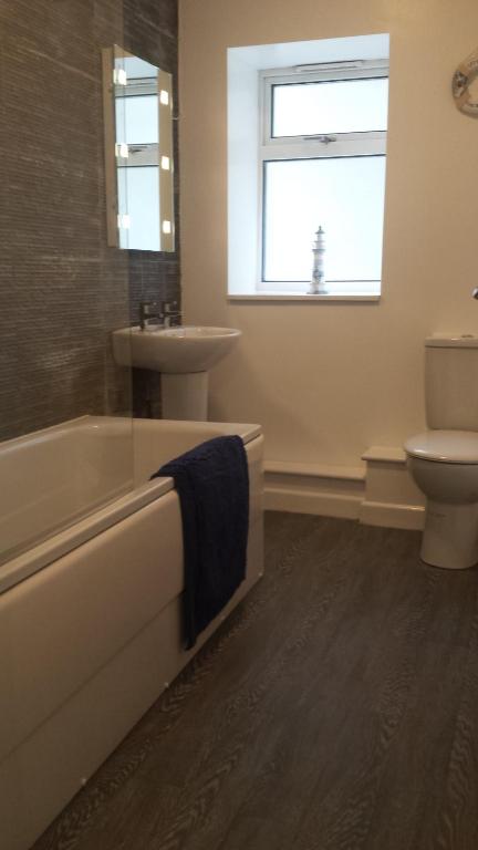 ein Badezimmer mit Badewanne, Waschbecken und Toilette in der Unterkunft 17 The Green Holiday Apartment in Tenby