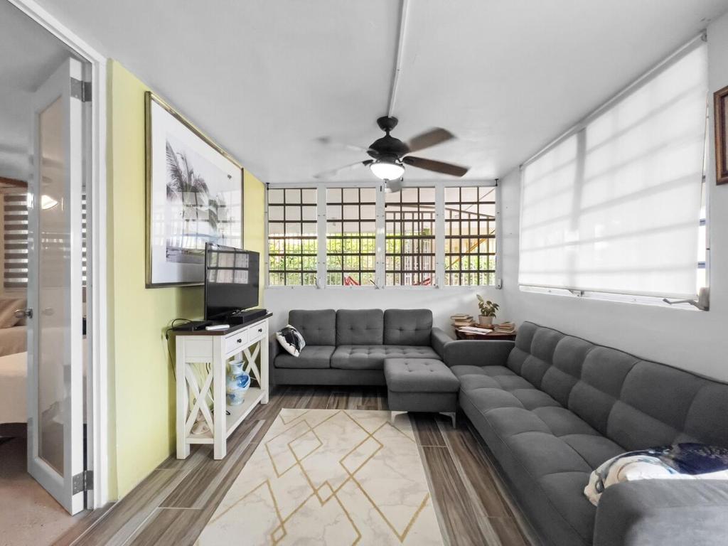 a living room with a couch and a tv at Tropical Naguabo Beach House Pool n Beach in Naguabo