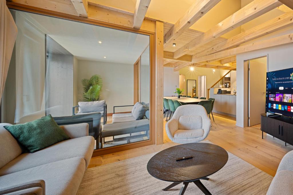 una sala de estar con un sofá y una mesa en Visionary Hospitality Bassersdorf, Zürich - Premium Apartments in Swiss Style with Free Parking, Washer, Kitchen, Terrace, Vaulted Cellar Event Room, Bus Stop, 15' City & Airport, en Bassersdorf