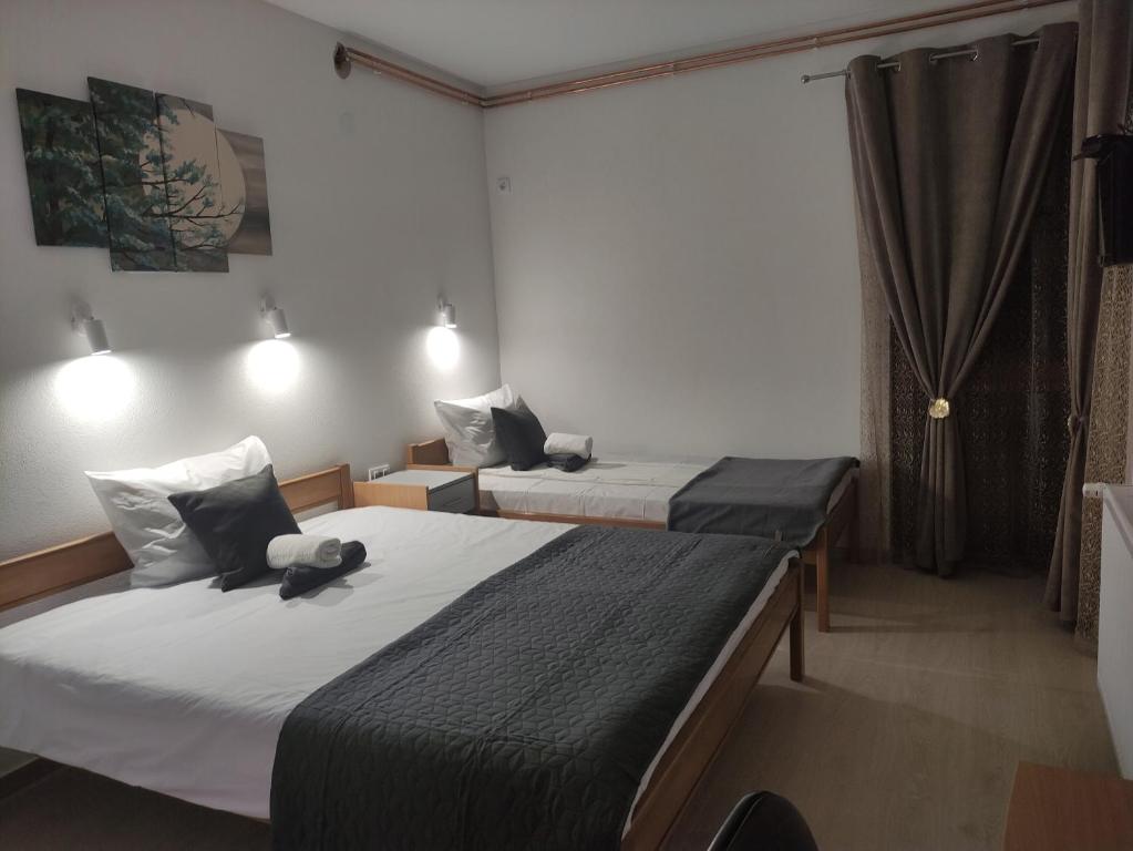 two beds in a small room with at Vila Čair DOPLATA ZA BAZEN in Soko Banja