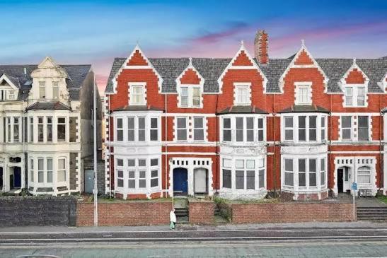 ein großes rotes Backsteingebäude mit weißen Fenstern in der Unterkunft Modern & Spacious 2-bed flat - Central Cardiff - Fast Wifi - Long & Short Stay in Cardiff