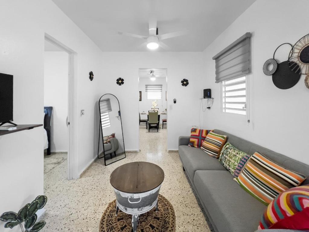 una sala de estar con un sofá y una mesa en Casa Luquillo Cozy Retreat House With Pool n Tub, en Luquillo