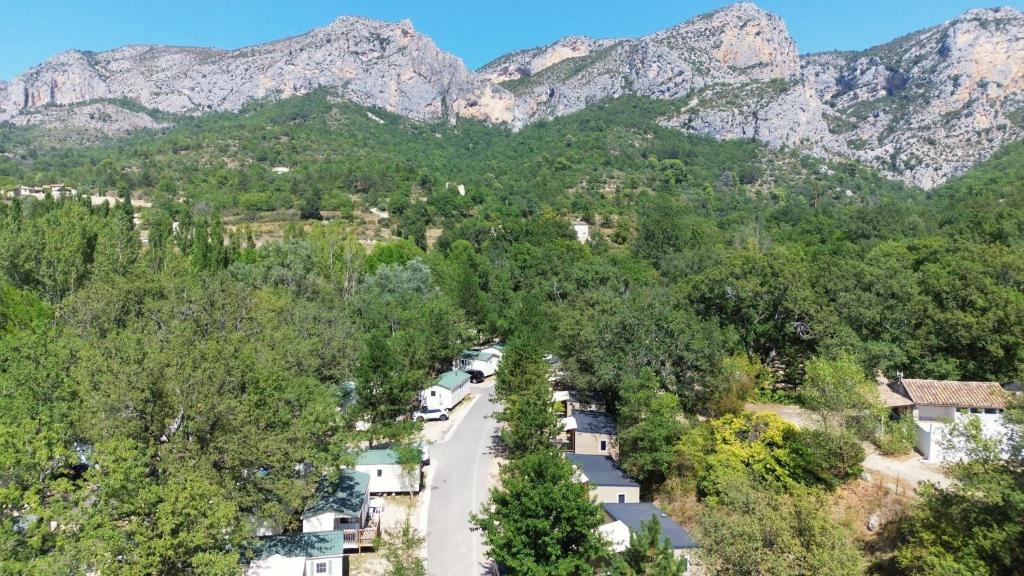 a road in the mountains with trees and houses at Camping Tikayan Saint Clair - Maeva in Moustiers-Sainte-Marie