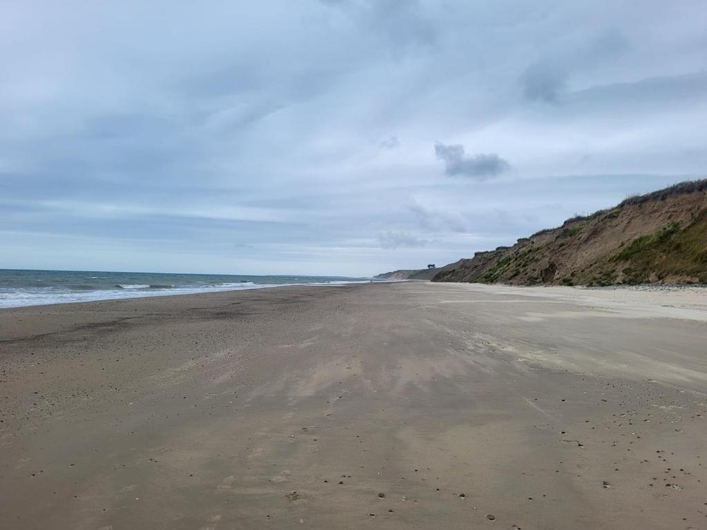 an empty beach with the ocean in the background at Sunny south east in Wexford in Blackwater