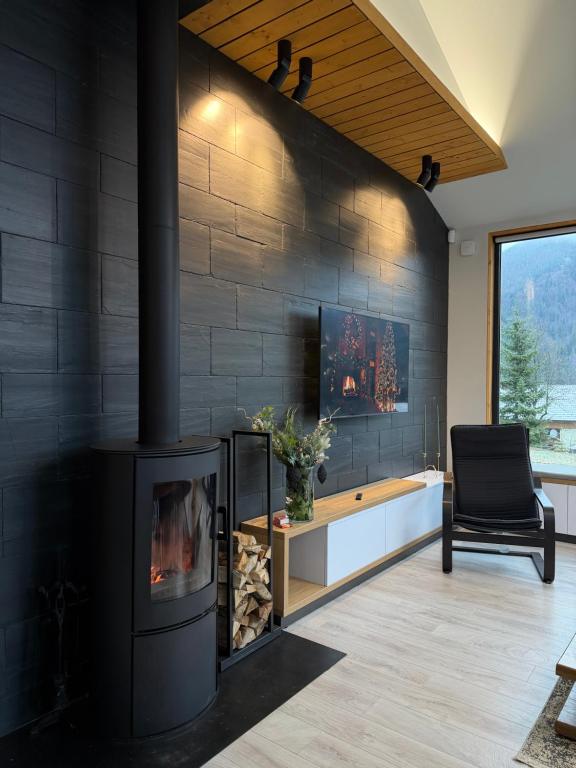 Una sala de estar con chimenea y una silla. en INOclub, en Tatariv