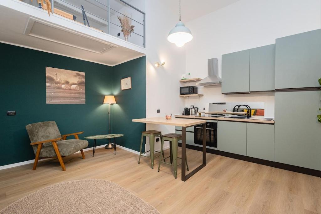 una cucina con mobili bianchi, tavolo e sedie di Living Bovisa a Milano