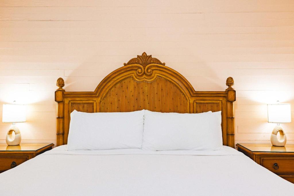 een bed met een houten hoofdeinde en 2 lampen bij Curry House Room 6 in Key West