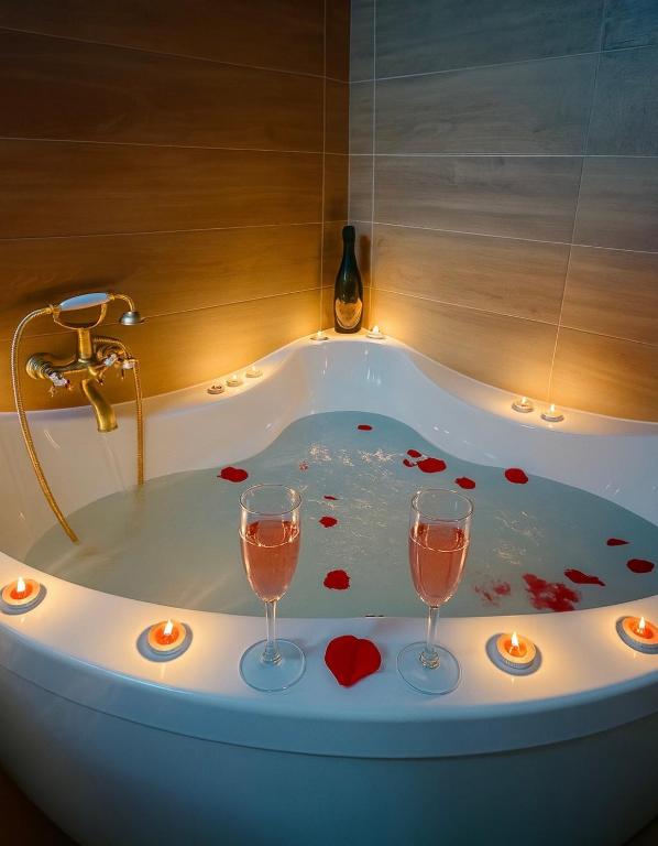two glasses of wine in a bath tub with hearts at Apartamento Rei Center in Merida