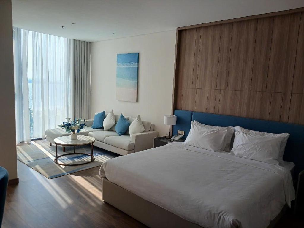 a bedroom with a large bed and a living room at A La Carte Hạ Long- Little Kun Homestay in Ha Long