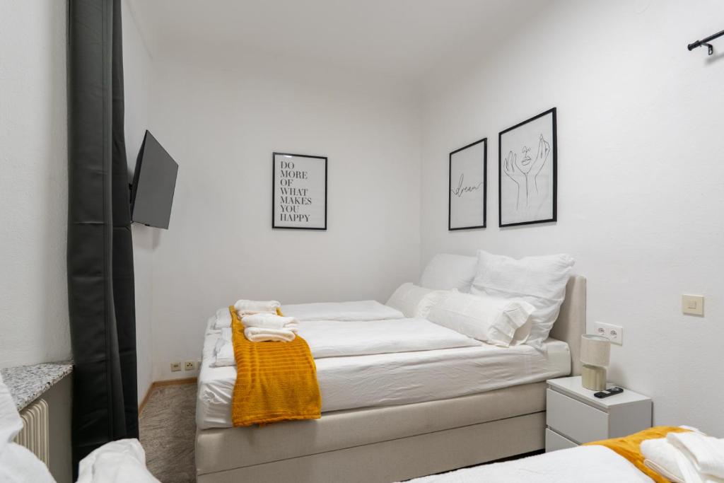 a white bedroom with a bed with a yellow blanket at Quiet - 4 Guests - Self Check-in - Netflix - 35m2 in Leoben