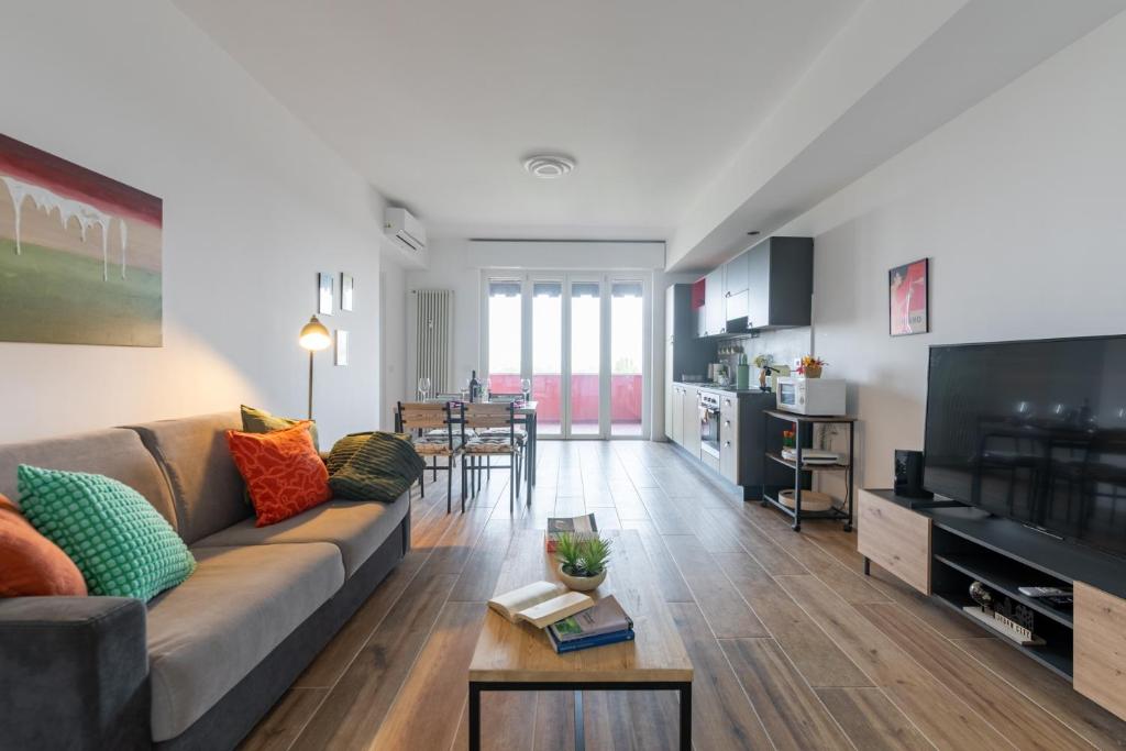 een woonkamer met een bank en een televisie bij Milano - Open Space in Cusano Milanino