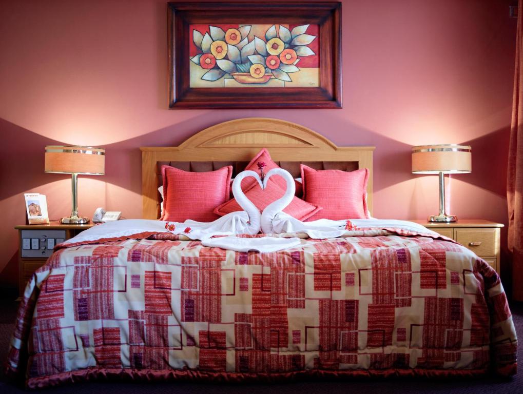 Un dormitorio con una cama con dos cisnes. en Cesar's Plaza Hotel, en Cochabamba