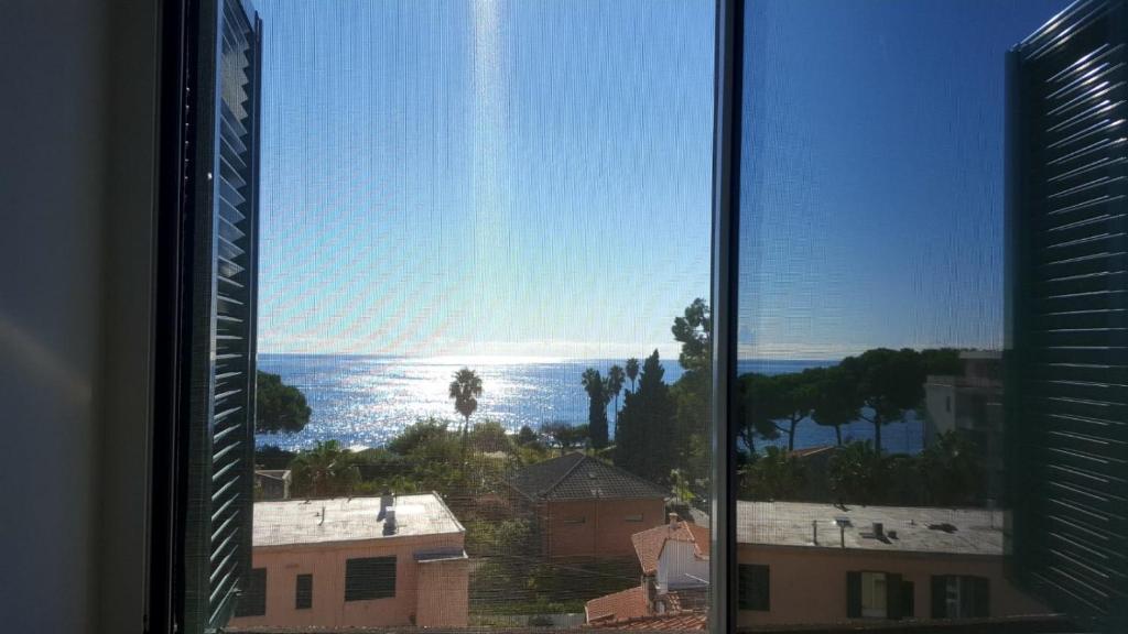 een raam met uitzicht op de oceaan bij Mansardina in Sanremo