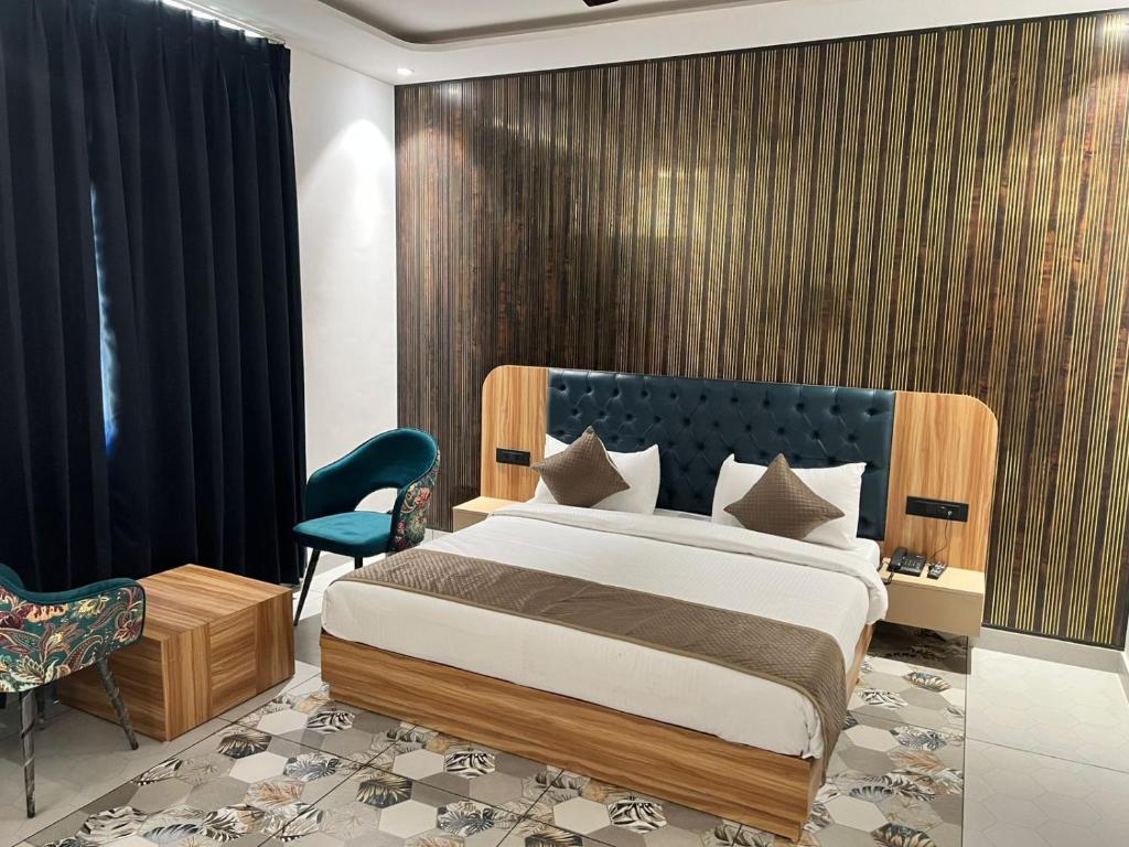 a bedroom with a large bed with a blue headboard at Troy Resorts and wellness in Zirakpur