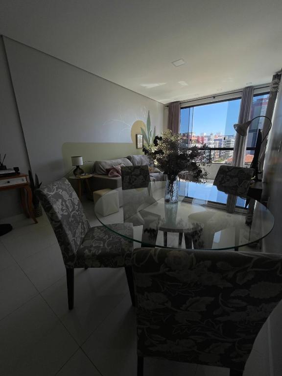 a living room with a glass table and a couch at Refúgio da Luz in Capão da Canoa