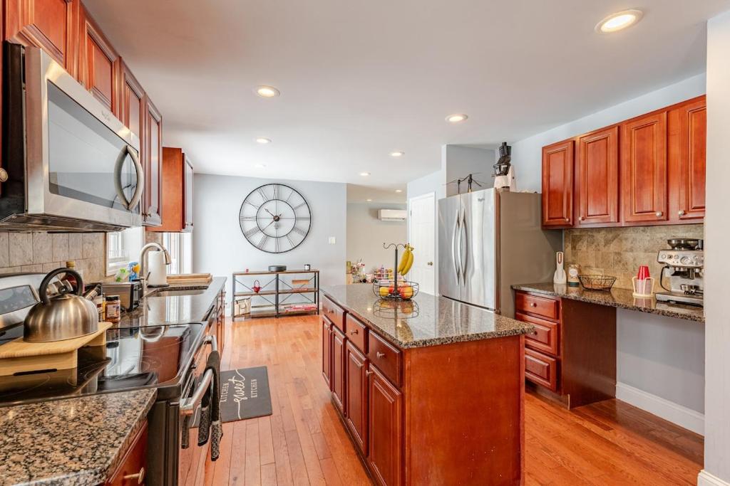 a large kitchen with wooden cabinets and a large clock on the wall at Lakeview Family Retreat Newly Renovated 4BR House in Pocono Country Place