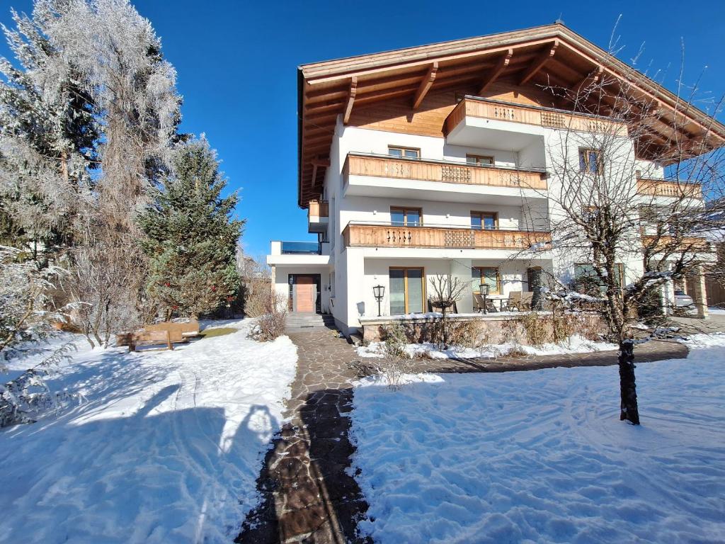 a building with snow in front of it at Panorama Apartments - Steinbock Lodges in Zell am See