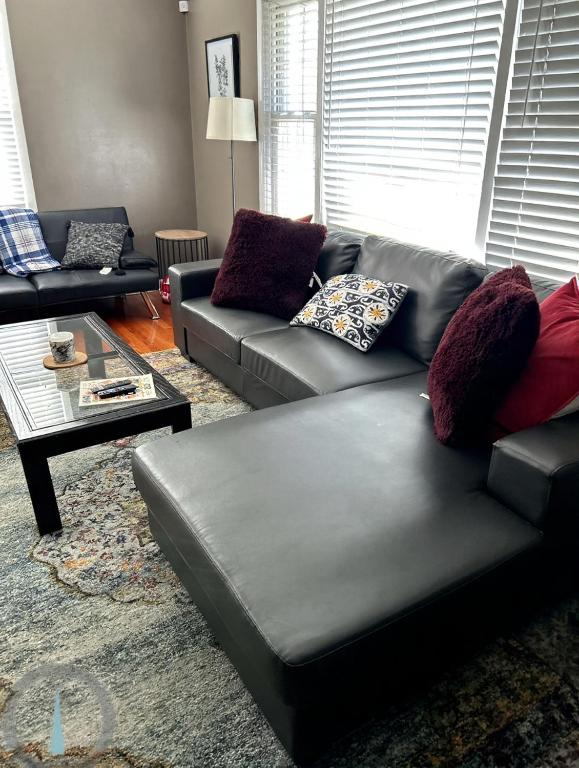 a living room with a leather couch and a coffee table at Spacious 4BR Close to Airport for Work and Families in Columbus