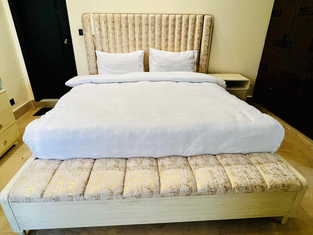 a bedroom with a large bed with a wooden headboard at OSMA Residency in Islamabad