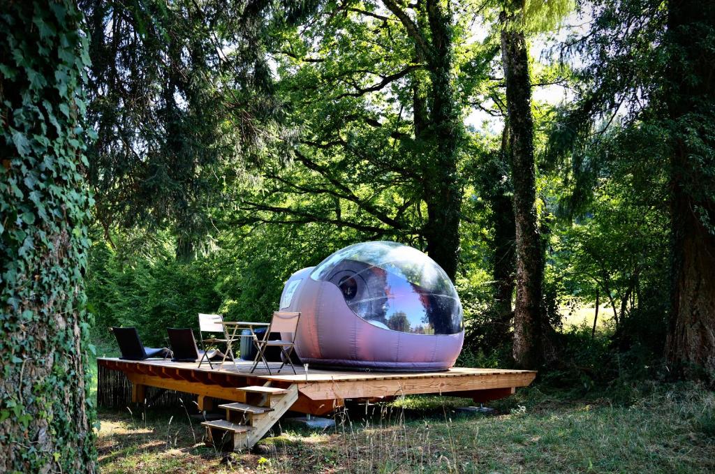 Monchateau étoilé, hébergement insolite avec Spa في Merlas: خيمة الجلوس على طاولة في الغابة