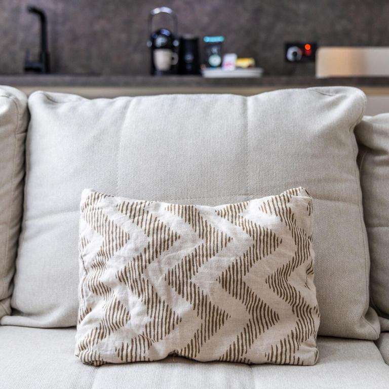 a pillow sitting on top of a white couch at Wild Thyme - By Solea Holiday Homes in San Ġwann