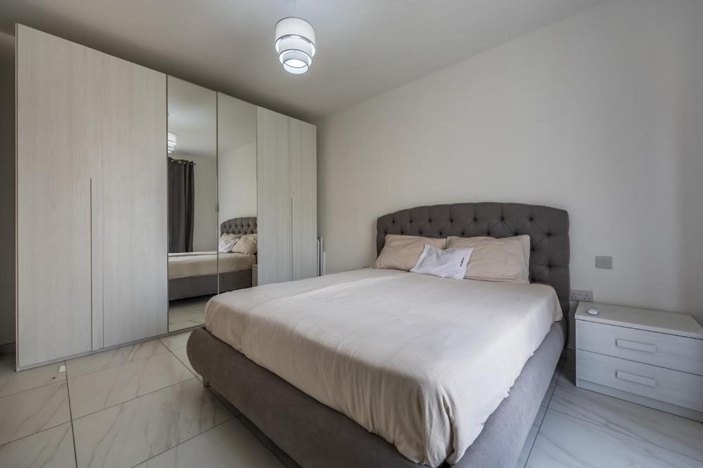 Wild Thyme - By Solea Holiday Homes في San Ġwann: غرفة نوم بها سرير كبير ومرآة