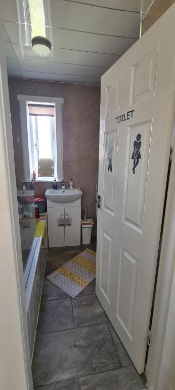 a bathroom with a toilet and a white door at Mel house in Fife