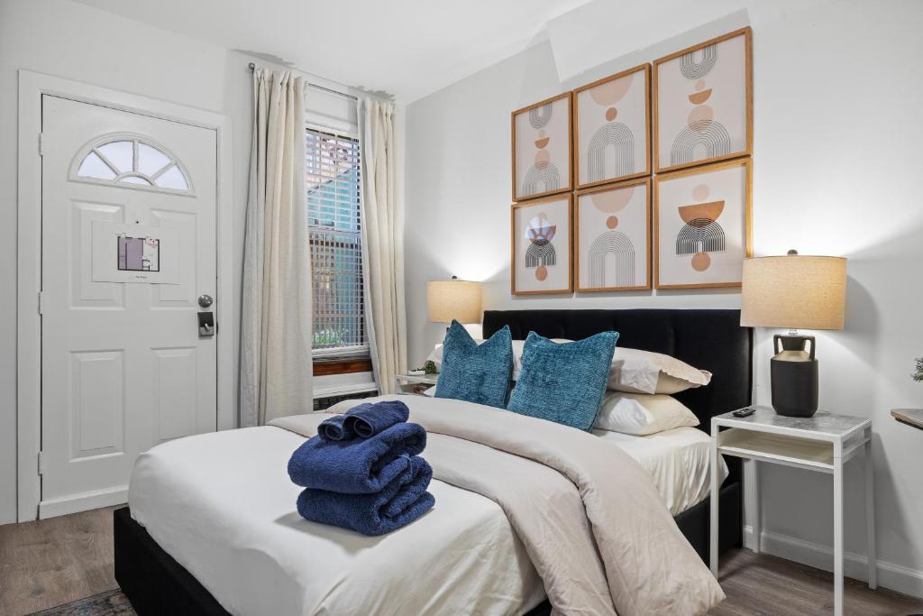 a white bedroom with two beds with blue pillows at Highly Recommended Studio Near Times Square in New York