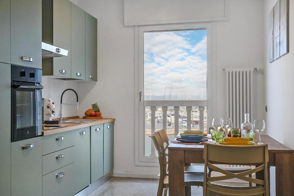 een keuken met een tafel met stoelen en een raam bij Casa Gabbiano by Ca-sa Check in Chioggia