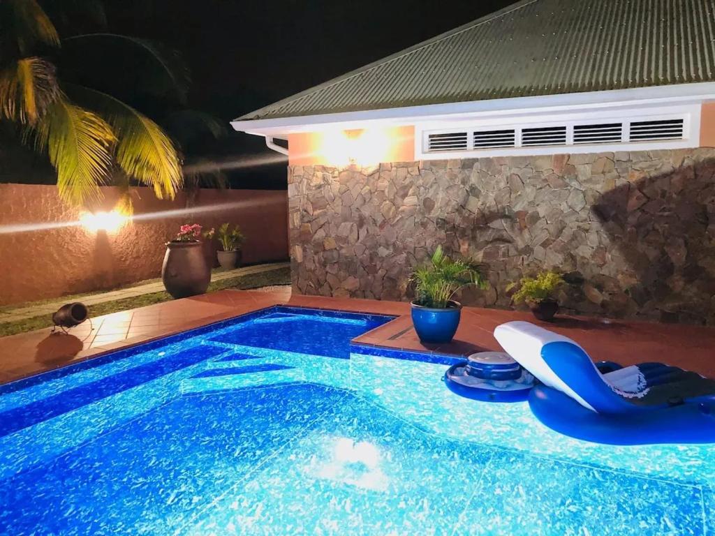 Una piscina en un patio trasero por la noche. en Bungalow confortable avec piscine à Le Lamentin, en La Belème