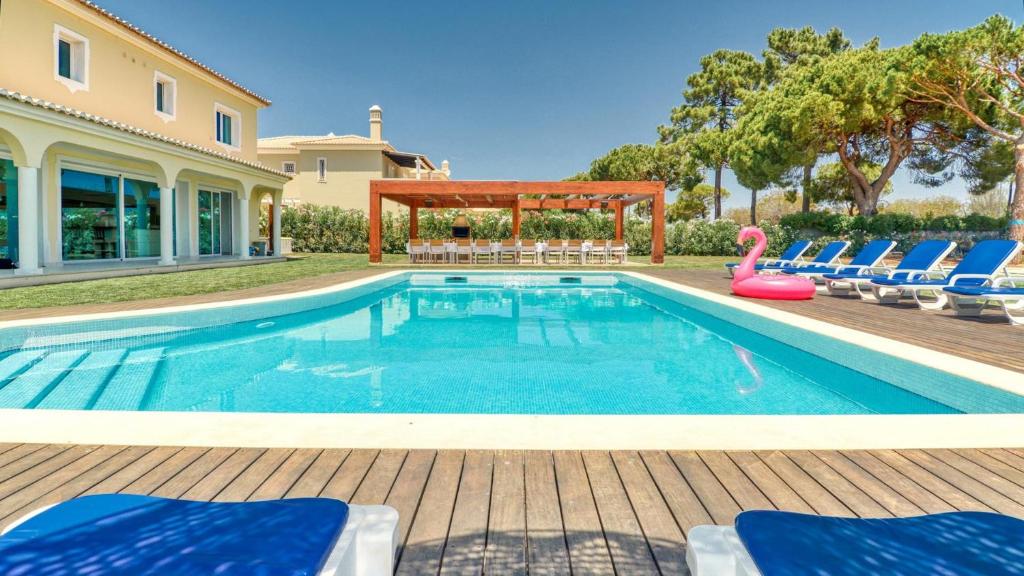 ein Swimmingpool mit Stühlen und einem Pavillon in der Unterkunft Dream Villa with Luxury Services - PROMOTION Last dates! in Vilamoura