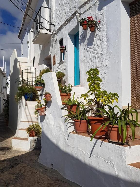 a white building with potted plants on a staircase at Casa Luna Miel in Frigiliana