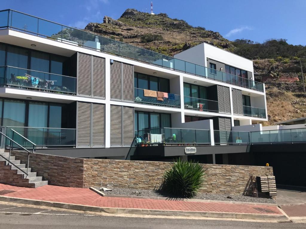 an apartment building with a hill in the background at Apto Vista Baía Machico in Machico