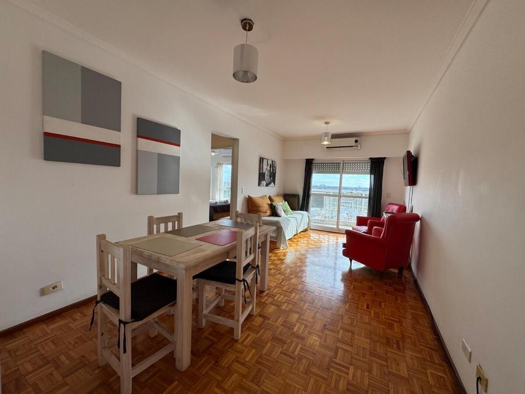 a living room with a table and a red chair at Tigre Centro A - piscina y seguridad 24hs - Opcional cochera paga in Tigre